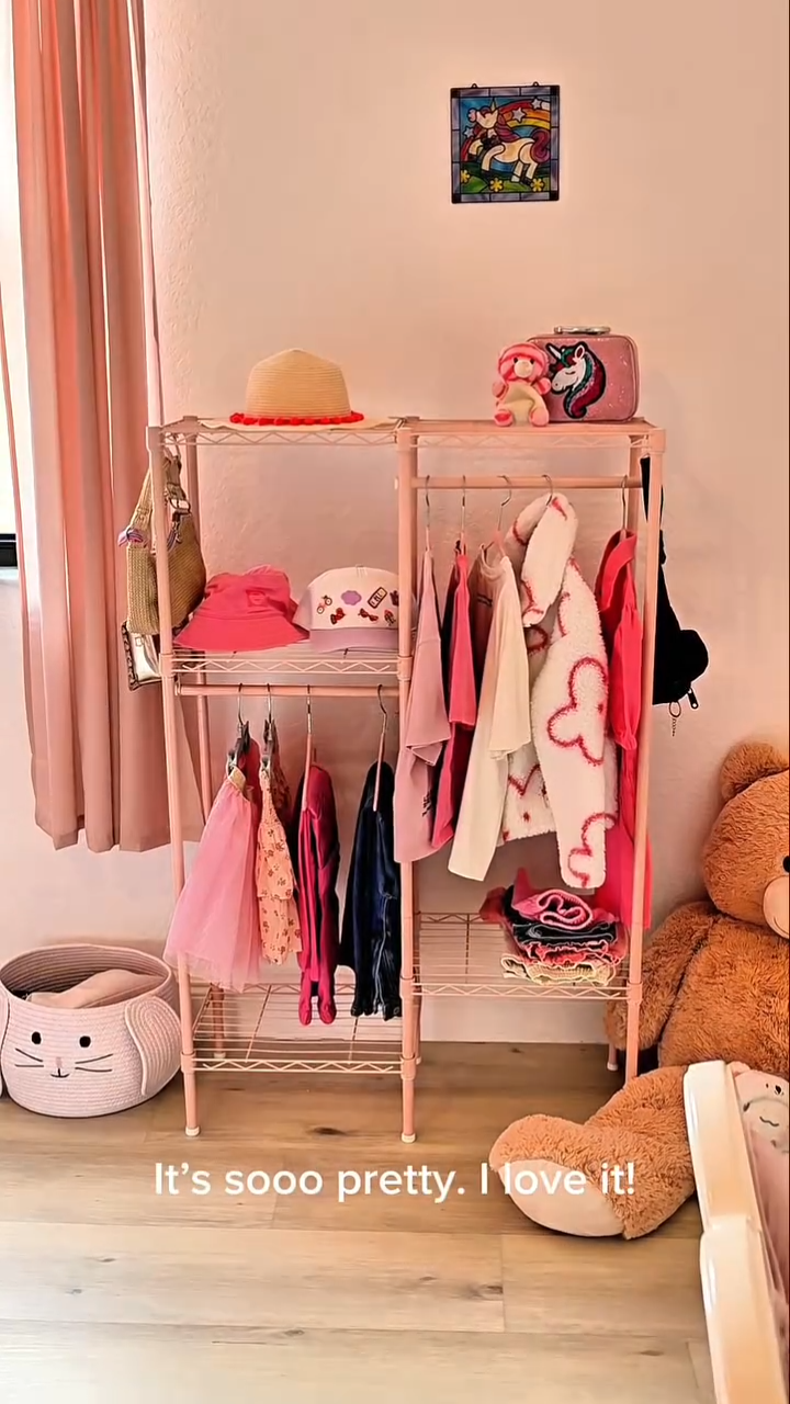 Black Ulif F1 garment rack holding children's clothes in a kids' room
